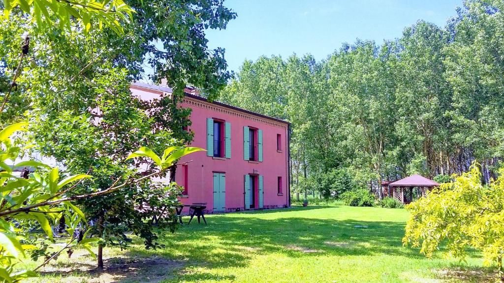 a pink house in the middle of a yard at Corte Stellata Holiday Apartments in Stellata