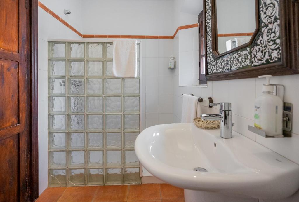 a bathroom with a white sink and a mirror at La Tartana Hotel Boutique in La Herradura