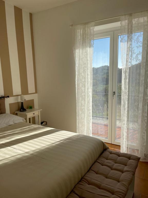 sypialnia z łóżkiem i dużym oknem w obiekcie Agriturismo Ippocastano w mieście Sciolze