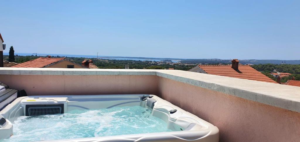 a hot tub on the balcony of a building at Rustic Istrian Stone House in Ližnjan