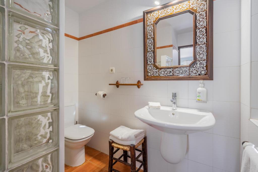 a bathroom with a sink and a toilet and a mirror at La Tartana Hotel Boutique in La Herradura