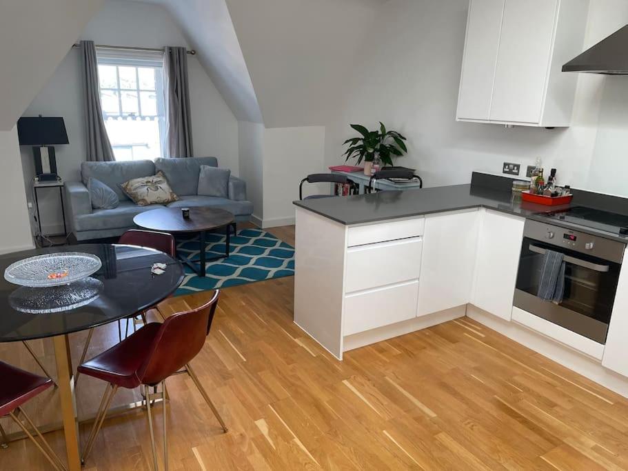 a kitchen and living room with a table and a couch at Lovely 2-bed flat with well equipped kitchen in Ealing