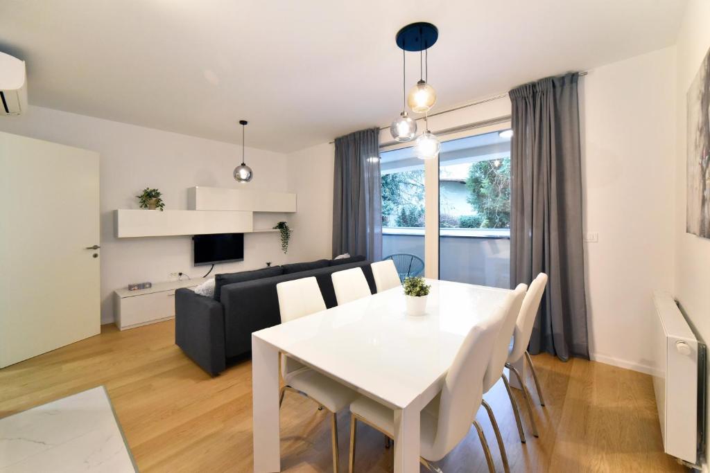 ein Esszimmer und ein Wohnzimmer mit einem weißen Tisch und Stühlen in der Unterkunft Ophelia Apartment with parking in Zagreb