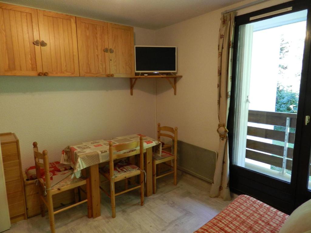 uma cozinha com uma mesa e cadeiras e uma televisão em Appartement Le Pleynet, 2 pièces, 5 personnes - FR-1-557A-45 em La Ferrière
