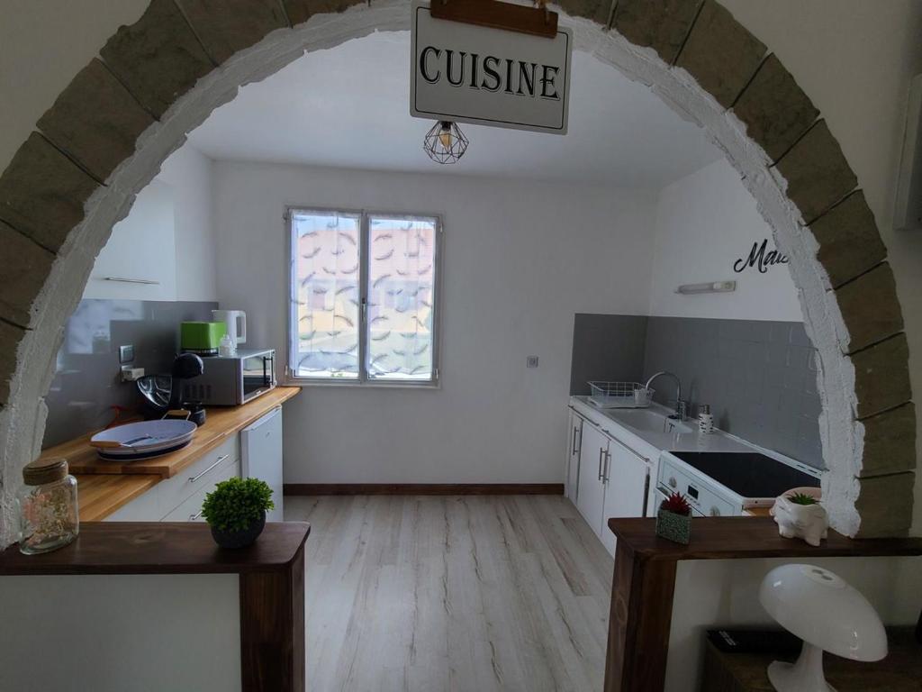 an archway in a kitchen with a sink and a counter at Gîte La Vôge-les-Bains, 3 pièces, 4 personnes - FR-1-589-418 in Harsault