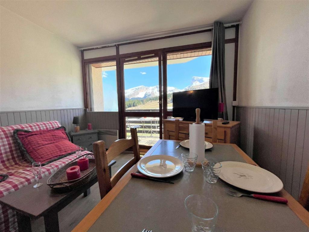 un salon avec une table et un canapé dans l'établissement Charmant 2 pièces cabine, balcon, parking, navette, wifi gratuit, proche commerces et pistes, 4 pers - FR-1-525-242, à Saint-Étienne-en-Dévoluy