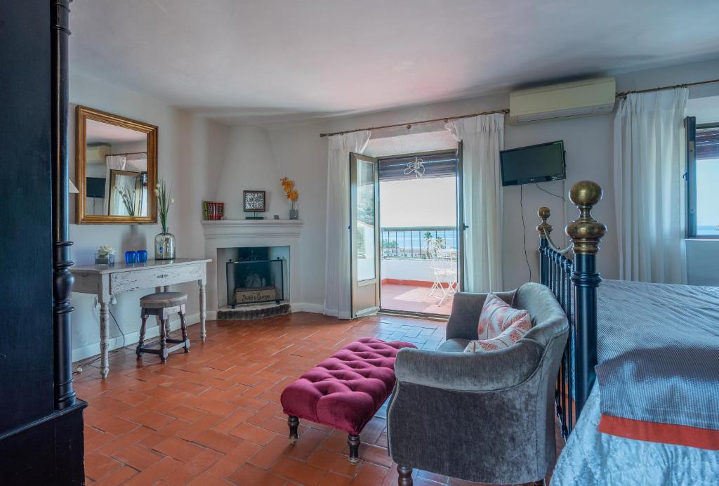 a bedroom with a bed and a living room with a fireplace at La Tartana Hotel Boutique in La Herradura