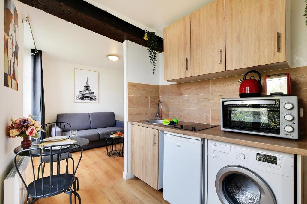 une cuisine et un salon avec laveuse et sécheuse dans l'établissement Studio in the heart of the Marais !, à Paris