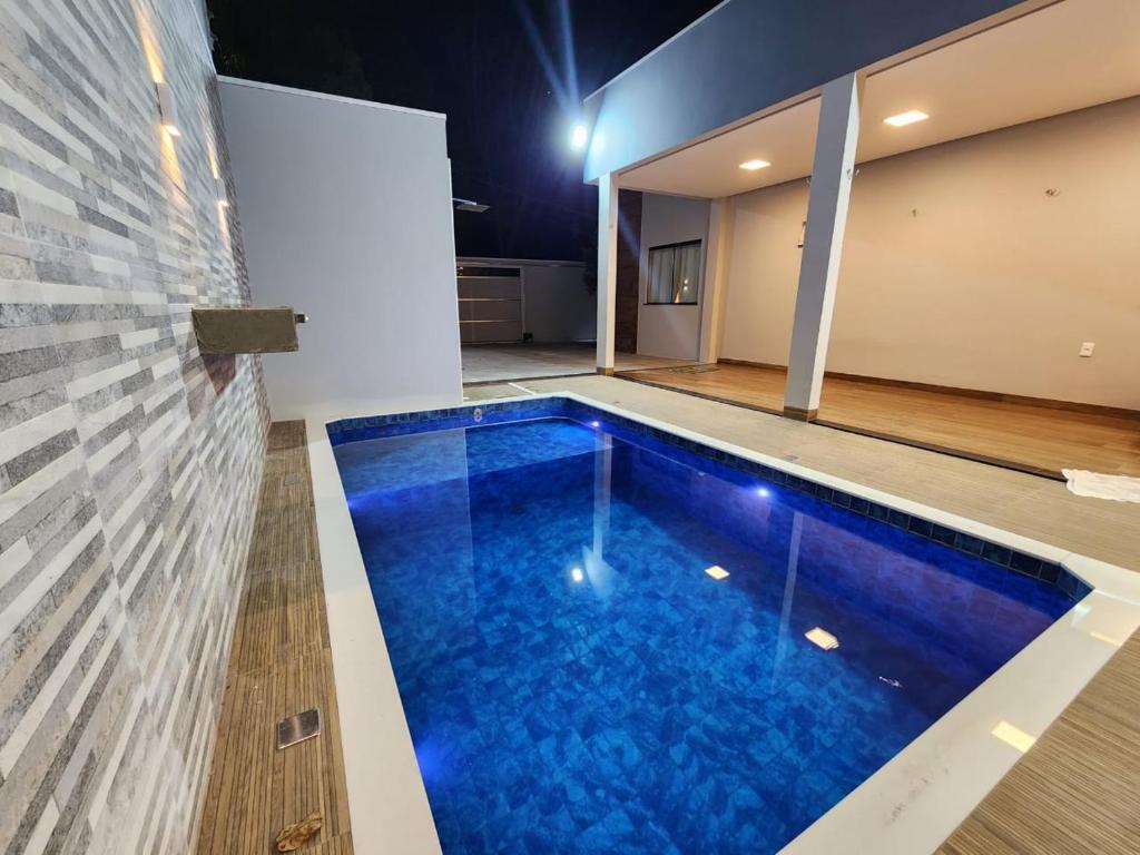 a swimming pool with blue water in a building at Casa em Alter Do Chão, com piscina, próxima a praia. in Santarém