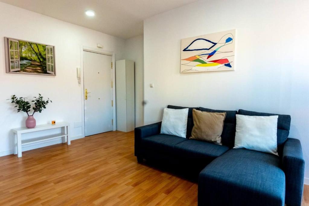 sala de estar con sofá azul y mesa en Homely 2 Bedroom Apartment in Barajas en Madrid