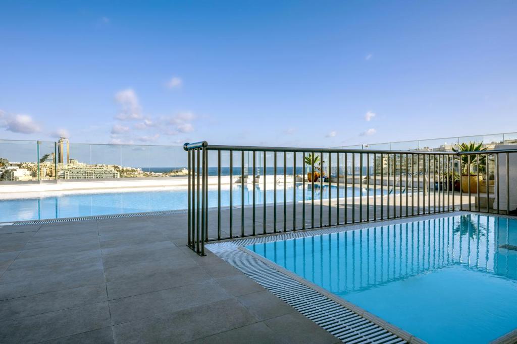 a swimming pool with a fence around it at Plaza Regency Hotels in Sliema