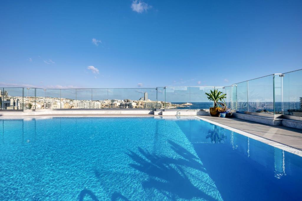 a large swimming pool with a view of a city at Plaza Regency Hotels in Sliema
