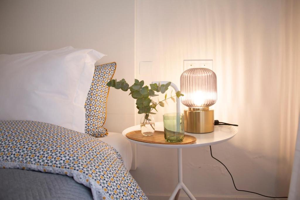 ein Schlafzimmer mit einem Tisch, einem Bett und einer Lampe in der Unterkunft Nido MAD in Madrid
