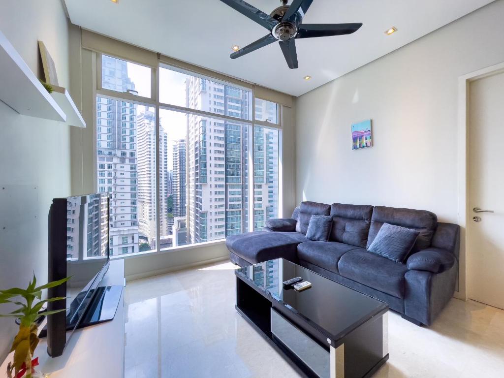sala de estar con sofá y ventilador de techo en Soho Suites klcc by i.desk, en Kuala Lumpur