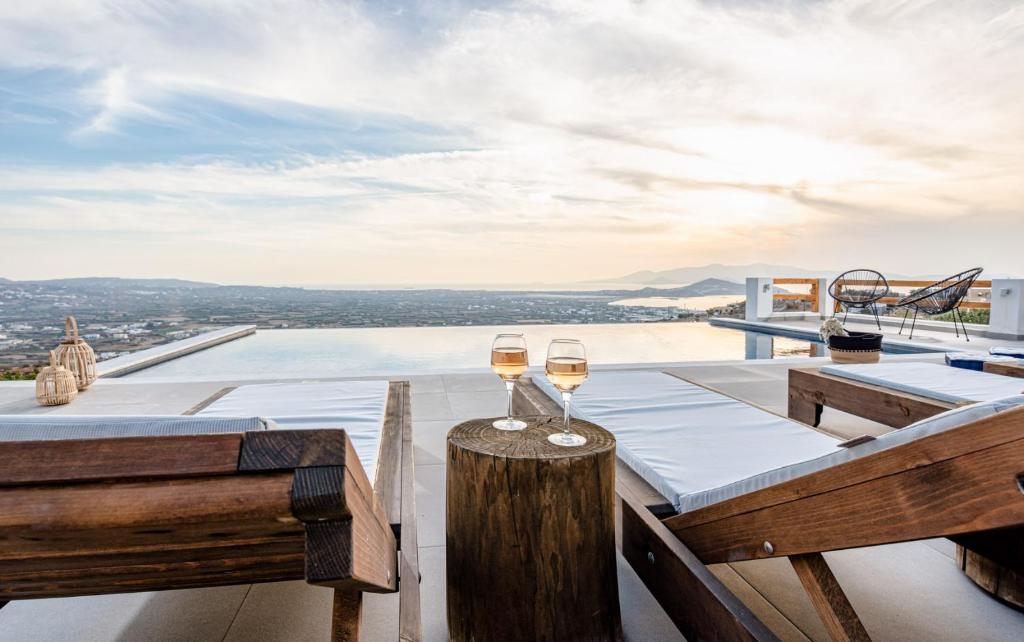 una mesa con dos copas de vino encima de una casa en Naxos Skyline Deluxe Villas, en Agkidia