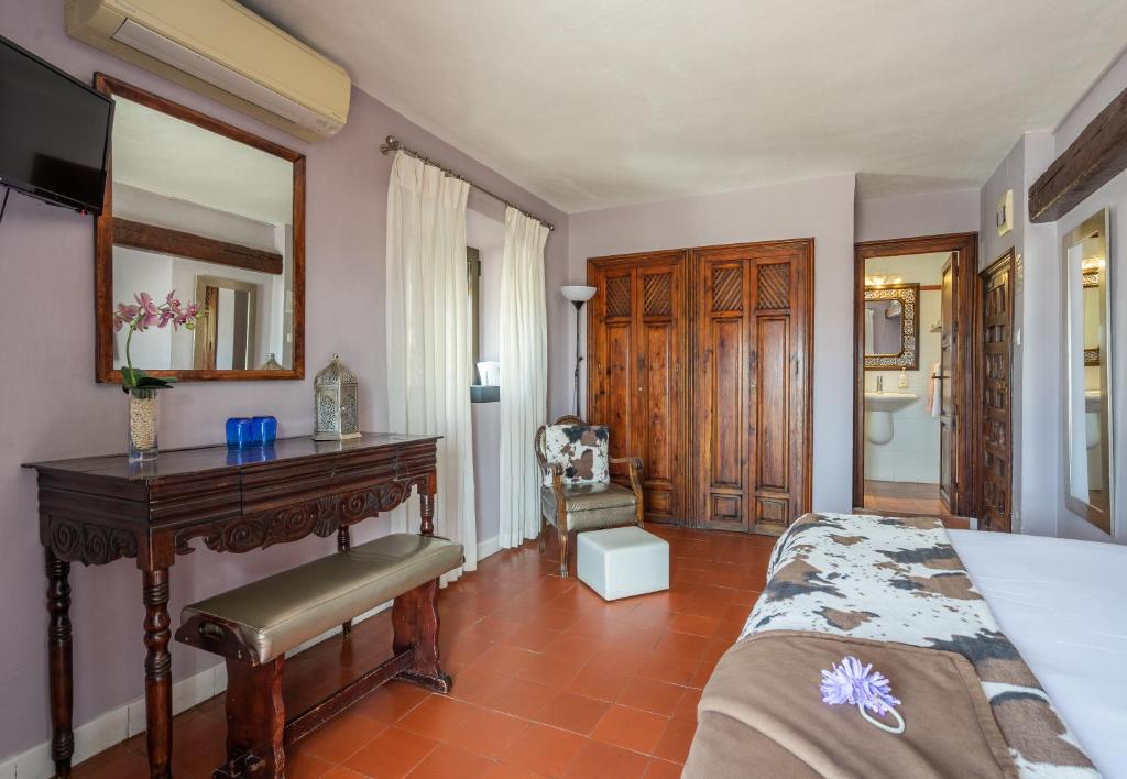 a bedroom with a bed and a desk and a mirror at La Tartana Hotel Boutique in La Herradura