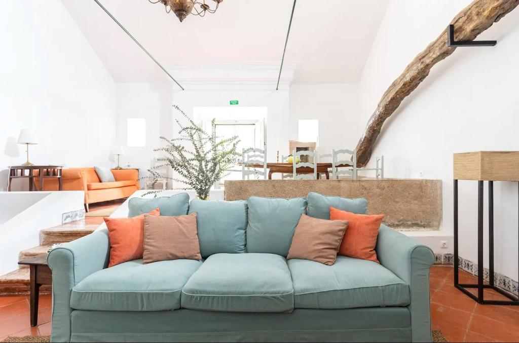 salon z niebieską kanapą z pomarańczowymi poduszkami w obiekcie Quinta de Cima,No campo é Assim w mieście Vila Franca de Xira