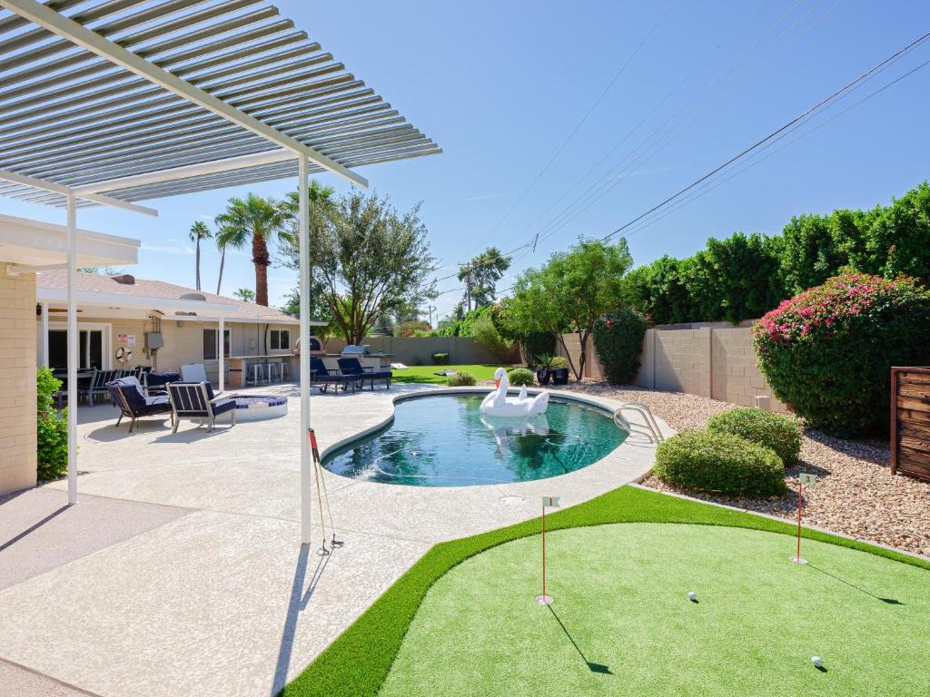 a swimming pool with a swan in a yard at Scottsdale - 4826 N 69th St in Scottsdale