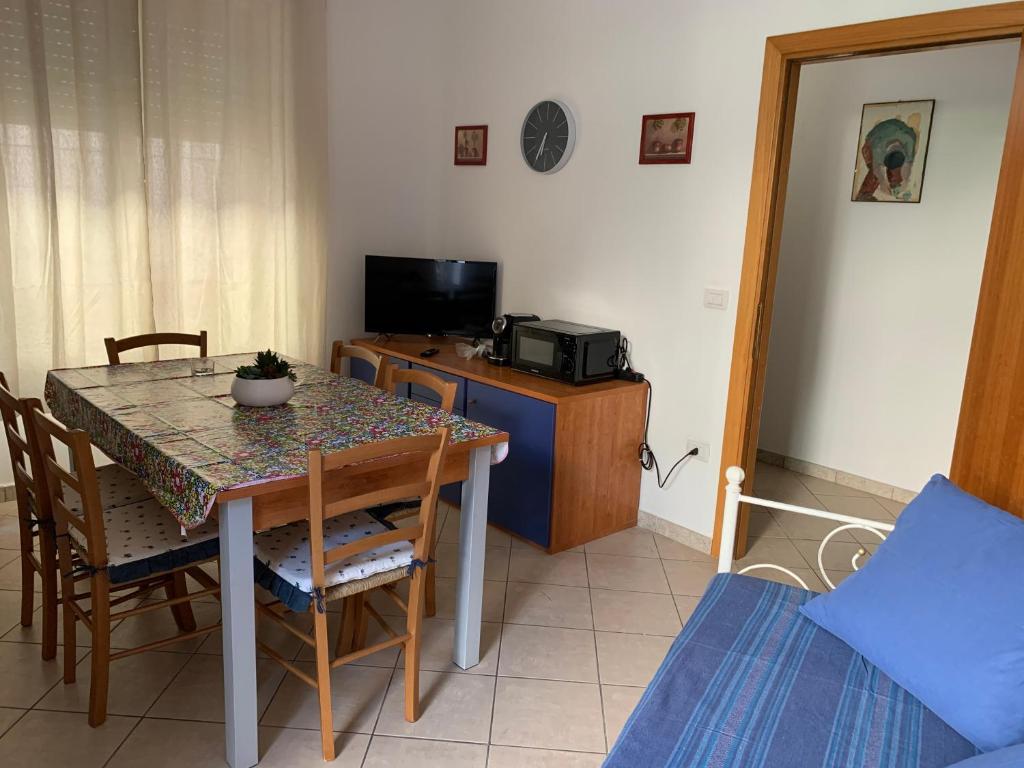 una sala da pranzo con un tavolo e una televisione di Casa Ziu Juanne a Orosei