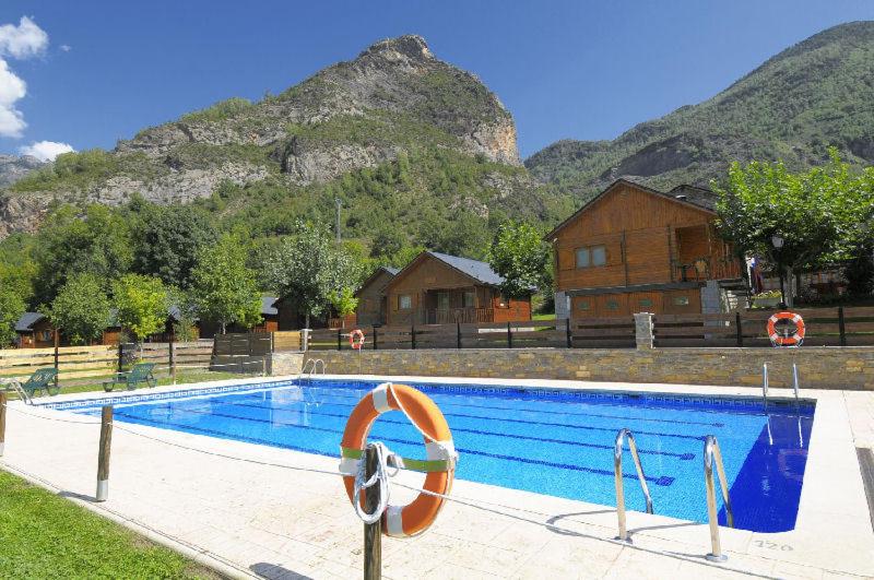 a swimming pool in front of a mountain at Bungalows La Borda d´Arnaldet in Villanova