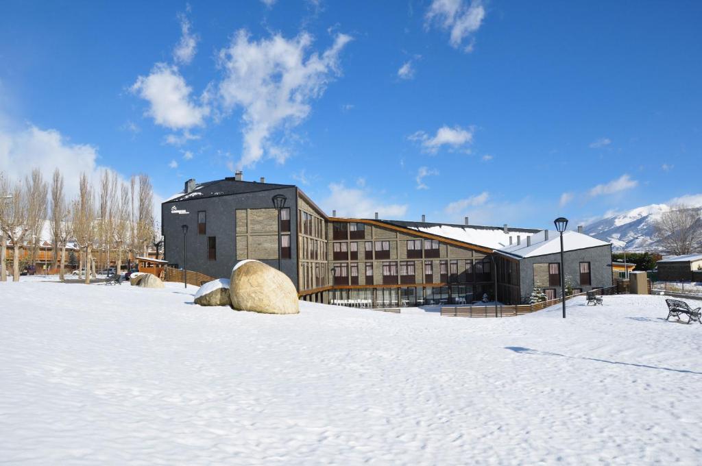 um edifício na neve em frente a um edifício em Campus Cerdanya em Puigcerdà