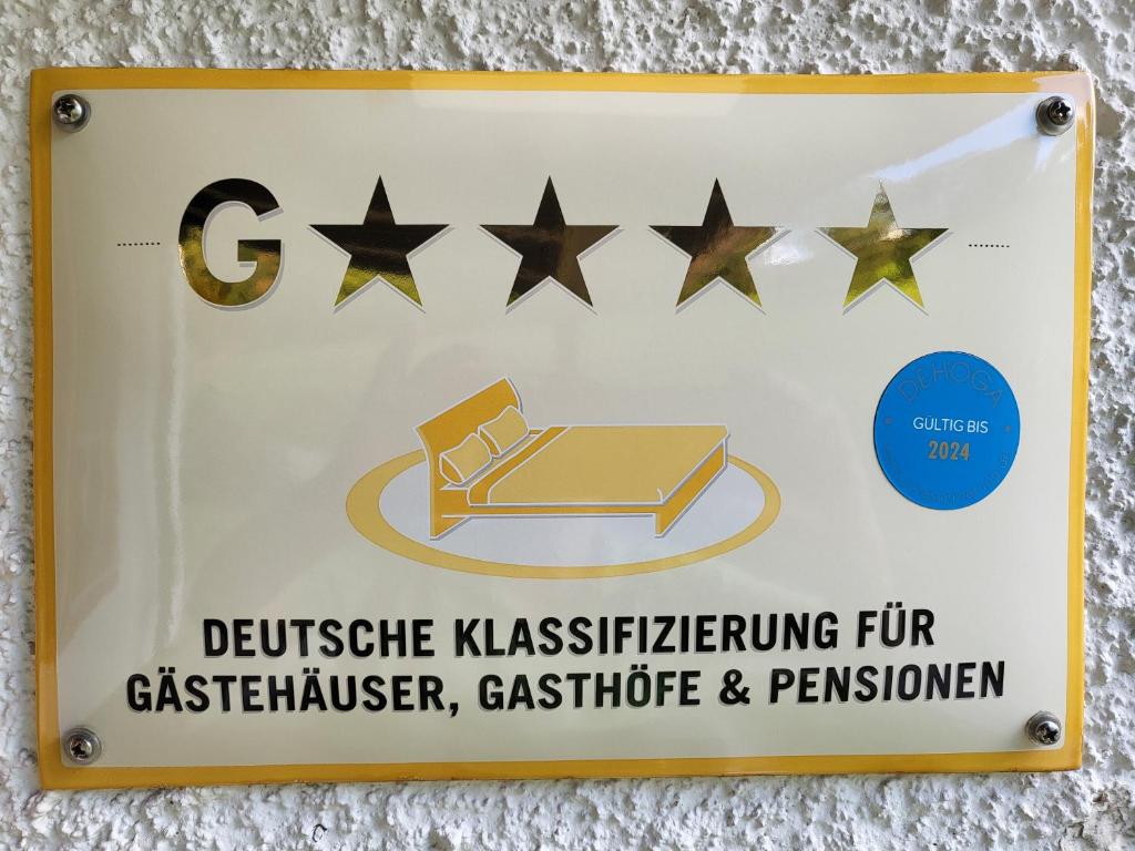 una señal en una pared con cinco estrellas en Die Oberlochmühle PENSION en Deutschneudorf
