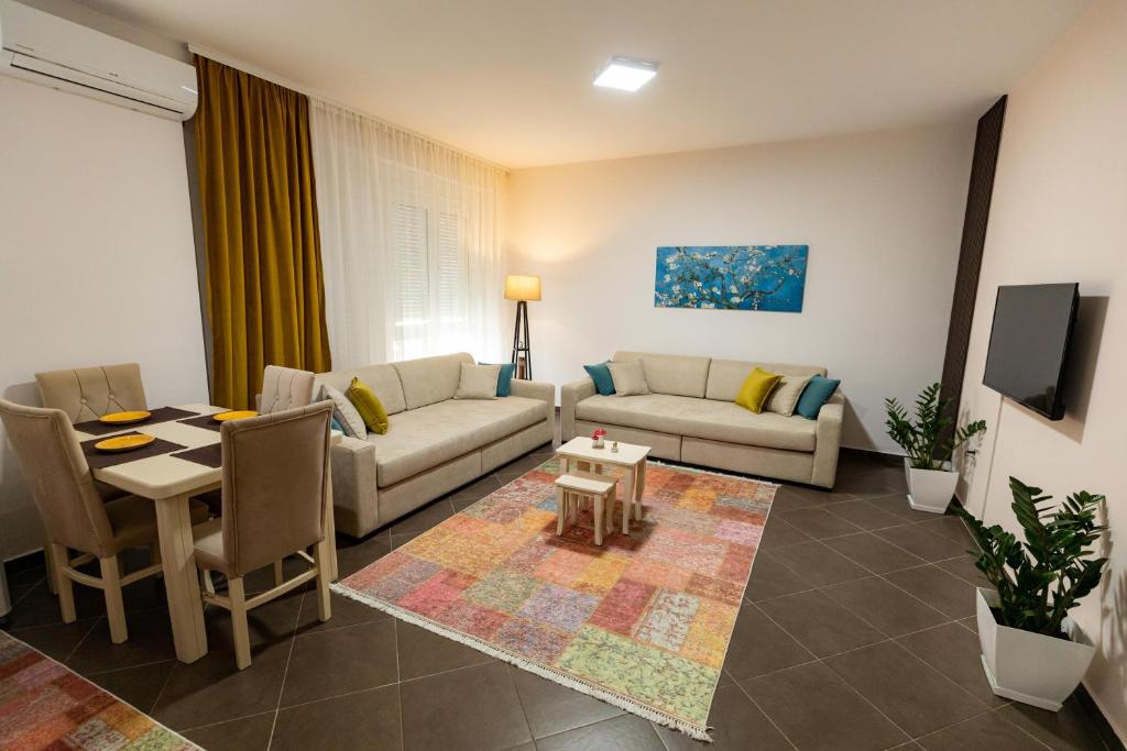 uma sala de estar com um sofá e uma mesa em Tirana Contact Apartment em Tirana