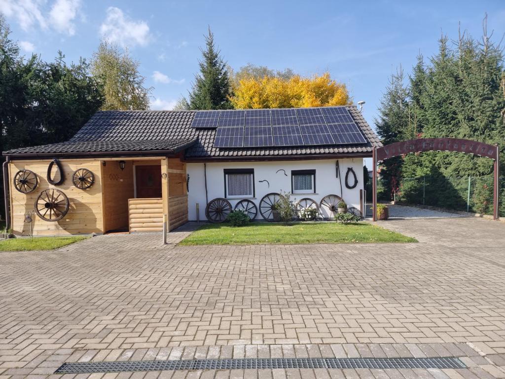 una casa con paneles solares en el techo en Villa Fantastica Apartments, en Mysłakowice