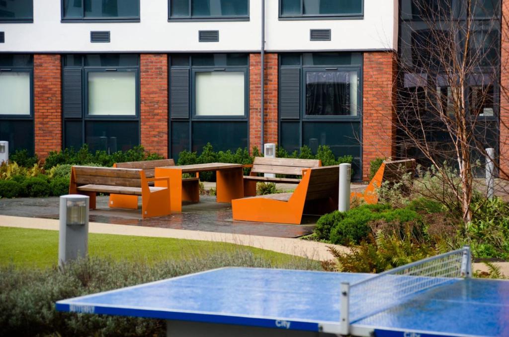 a picnic table and benches in front of a building at For Students Only - Premium Accommodation at Eclipse Student Accommodation in Cardiff in Cardiff