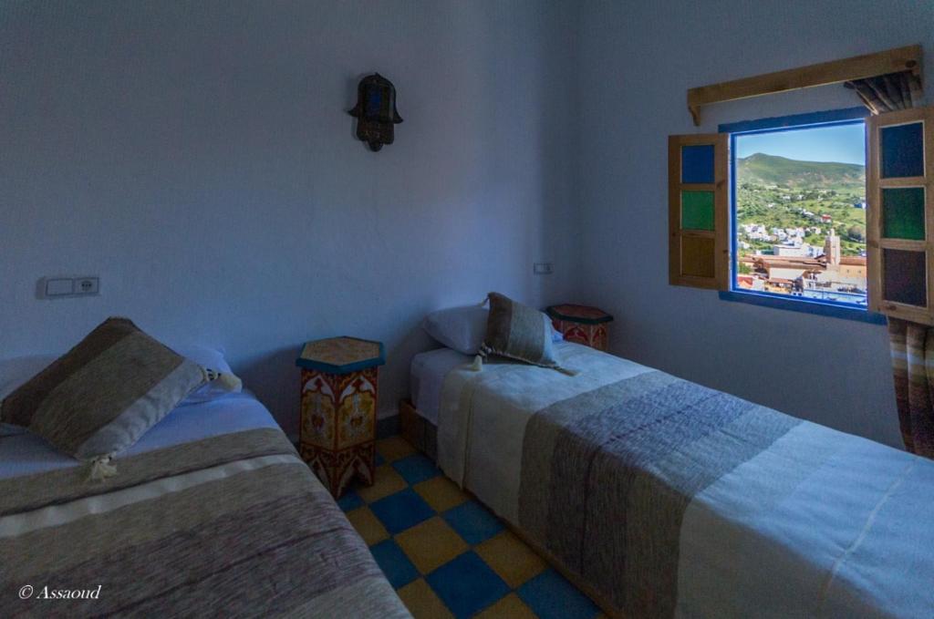 a room with two beds and a window at Dar El Fanne in Chefchaouen