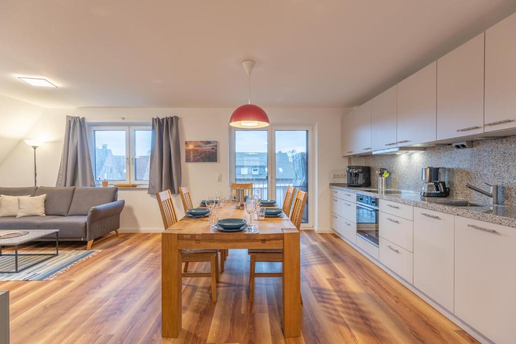 a kitchen and living room with a table and a couch at Getidenhus Sünn in Sankt Peter-Ording