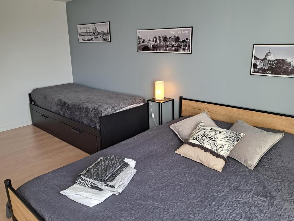 1 dormitorio con 1 cama y 2 camas. en Gite des falaises de Longues 8personnes, en Longues-sur-Mer