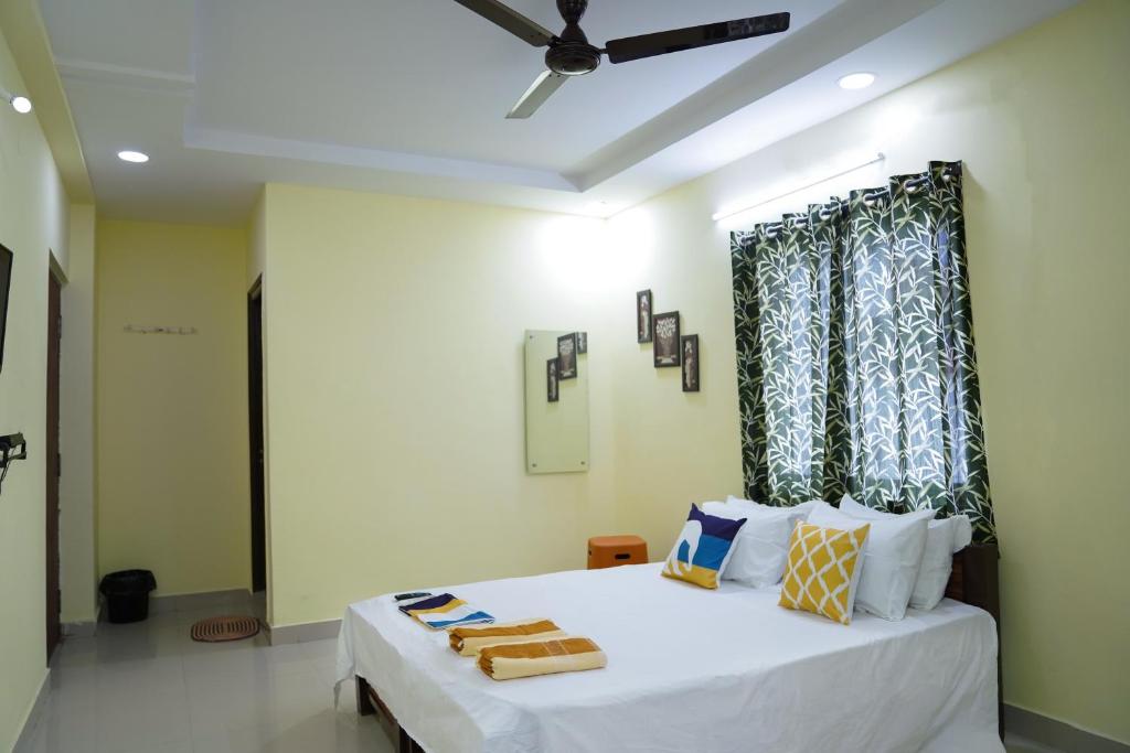 Schlafzimmer mit einem großen weißen Bett und einem Fenster in der Unterkunft Hotel Yellow Bells in Hyderabad