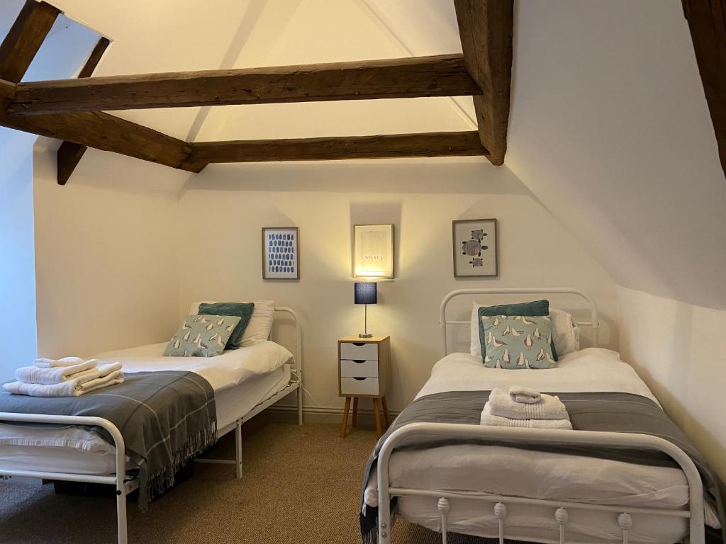 two twin beds in a room with a roof at Grade II Listed 2 Bed Cottage with Free Parking in King's Lynn