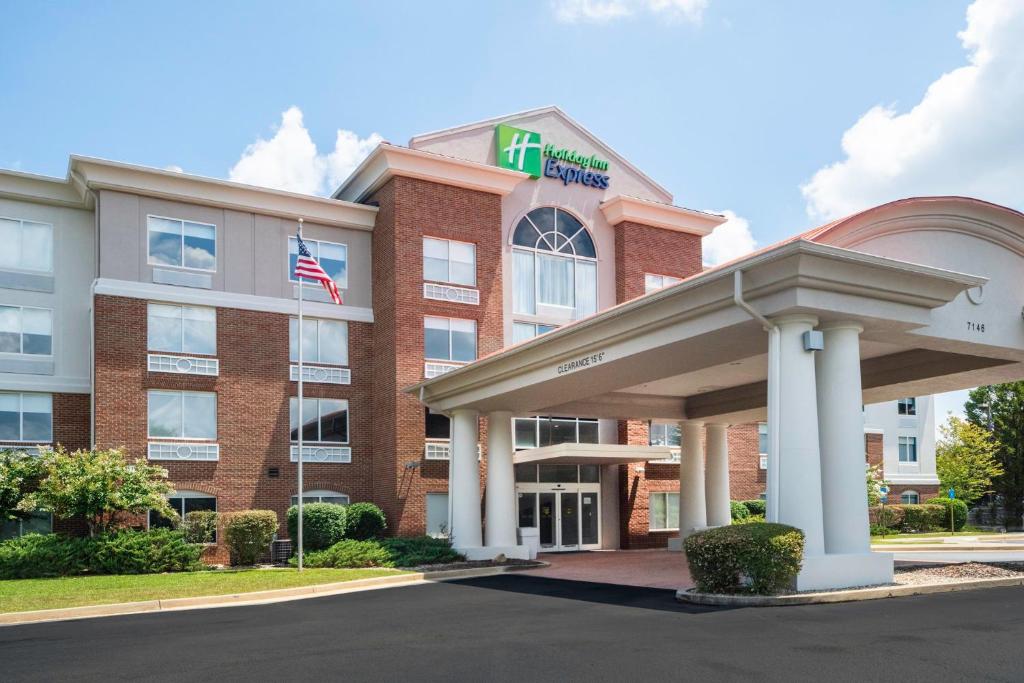 a hotel with an american flag in front of a building at Holiday Inn Express and Suites Atlanta-Johns Creek, an IHG Hotel in Johns Creek