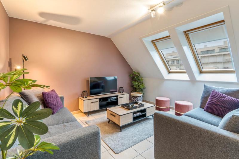 a living room with two couches and a tv at Gaugain E 601 in Nieuwpoort