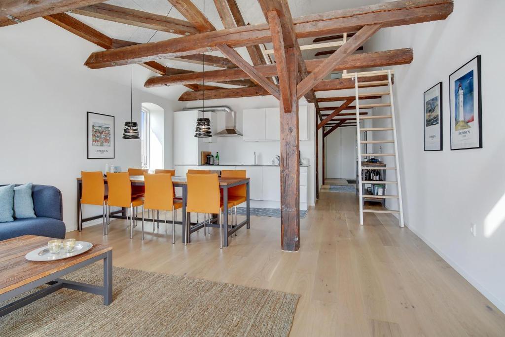 a kitchen and dining room with a table and chairs at Completely Renovated Holiday Apartments in Løkken