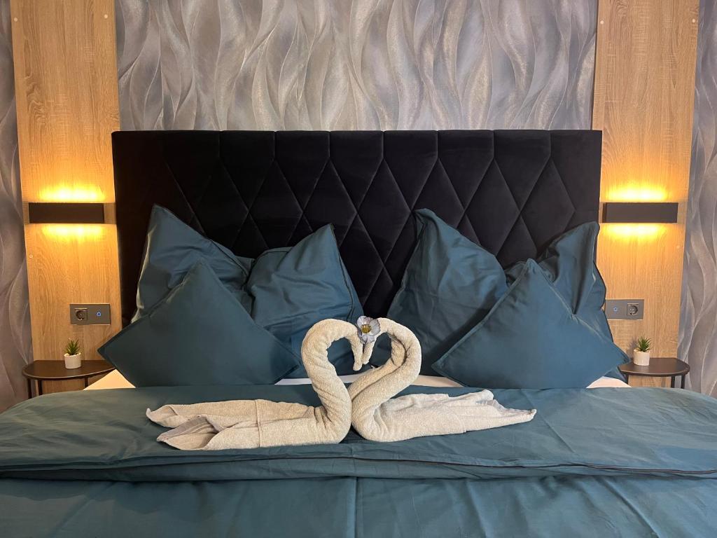 Dos cisnes de toalla haciendo un corazón en una cama en Frühstückspension Elena Nicoleta Caltun en Fischamend Dorf