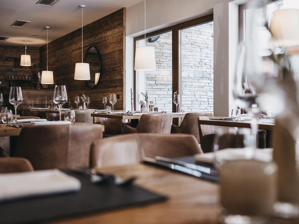 a restaurant with tables and chairs and windows at VAYA Sölden inklusive Summer Card in Sölden