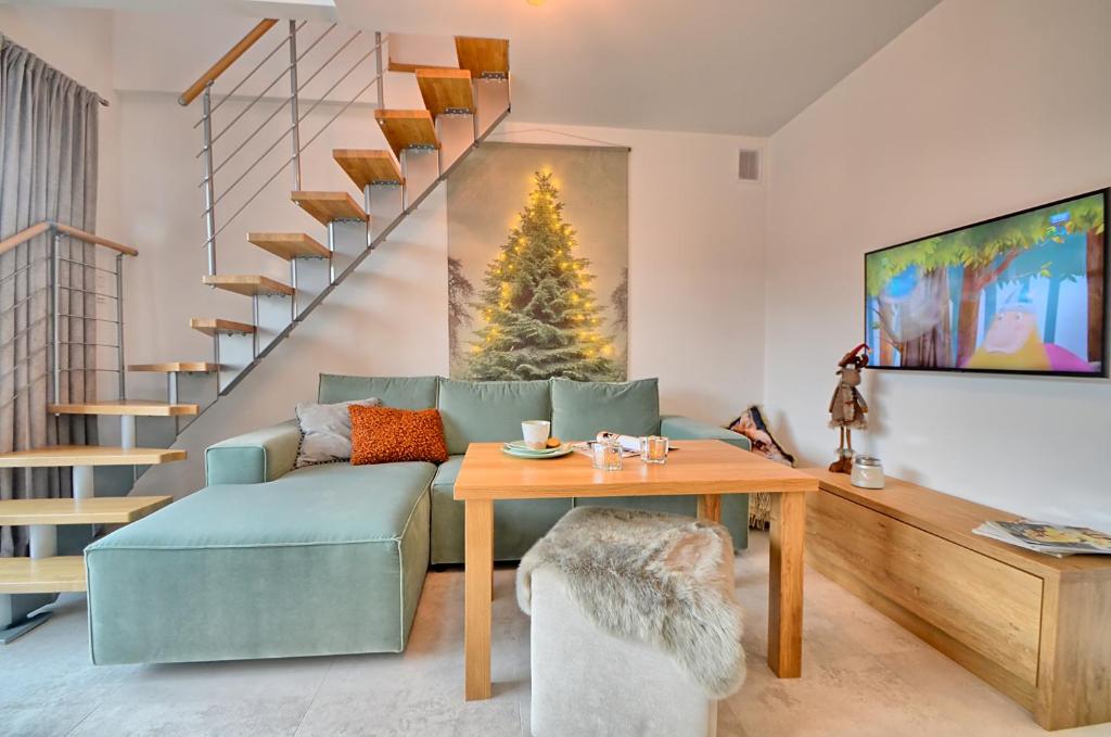 a living room with a couch and a table at Apartament Pistacjowy in Szczyrk