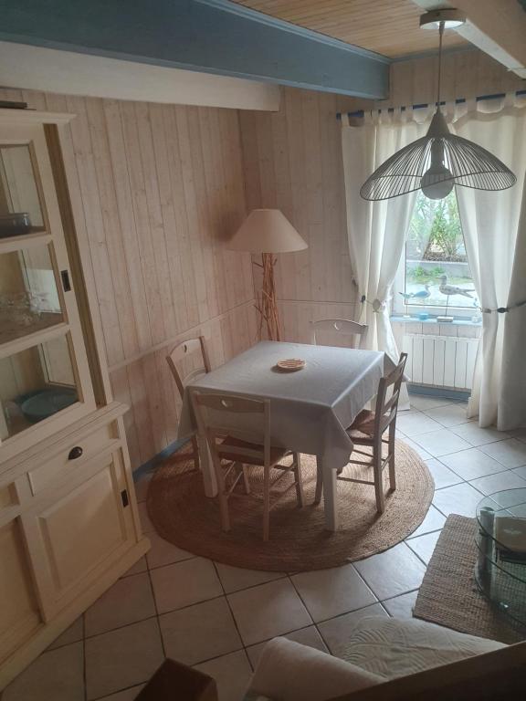 a dining room with a table and chairs and a window at penty vero in Plobannalec-Lesconil