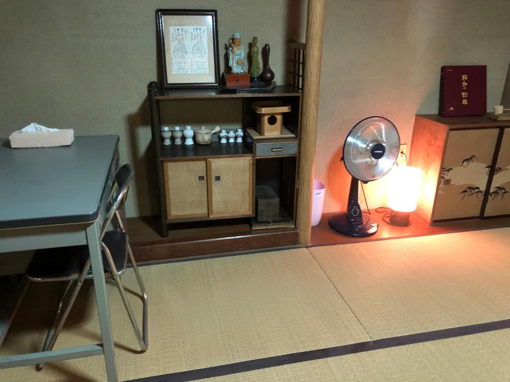 Camera con scrivania e tavolo con ventilatore. di 桃源郷２ a Toba