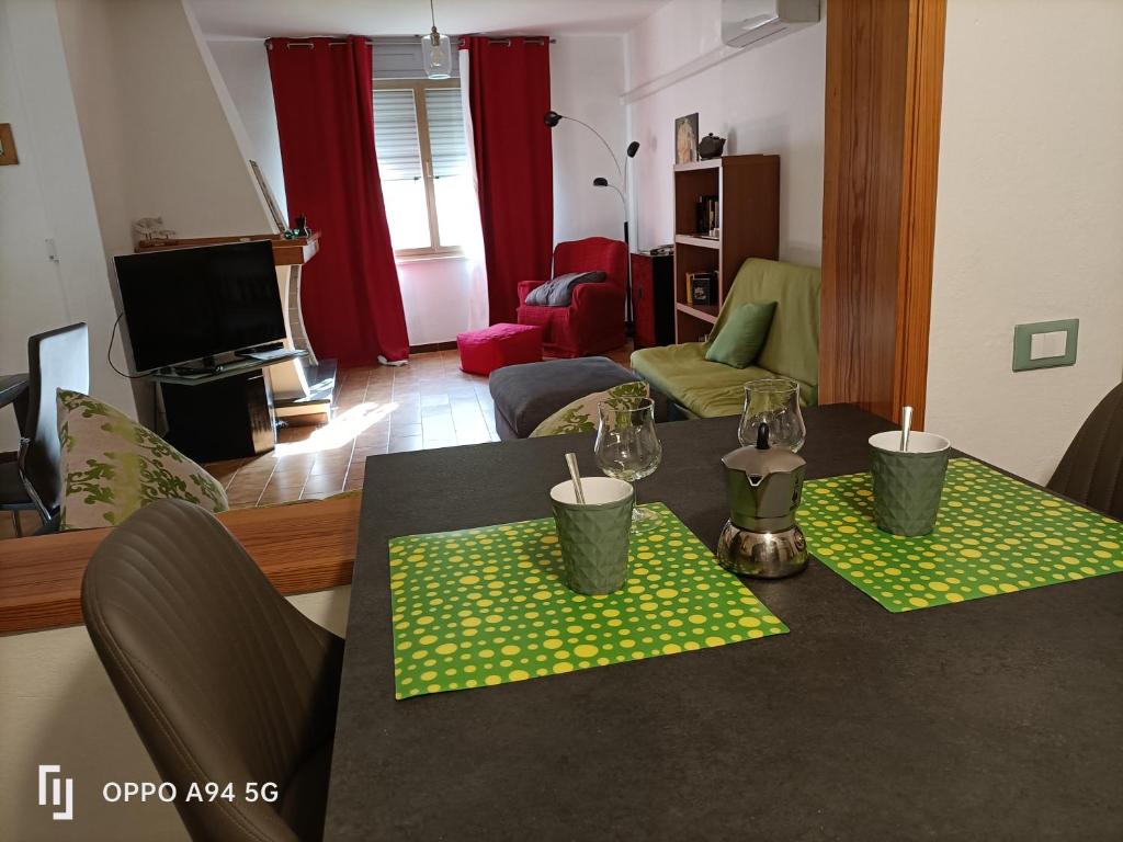 una sala de estar con una mesa con servilletas verdes y velas en Villa Zagara, en Domus de Maria
