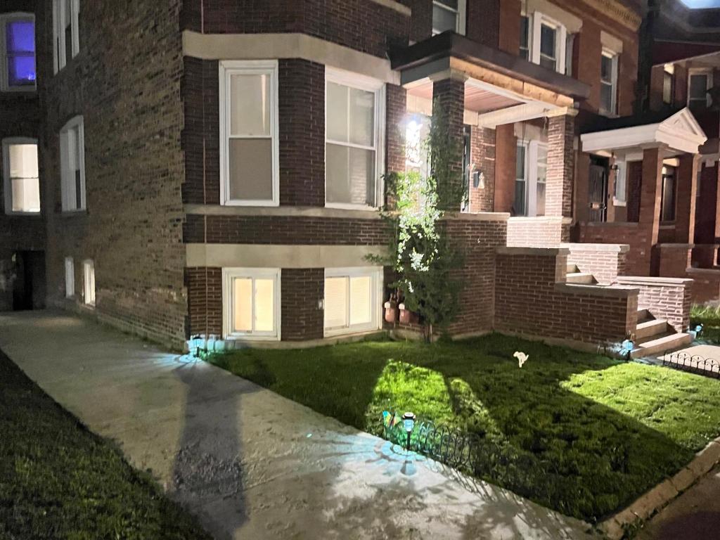 una casa de ladrillo por la noche con césped verde en Simplified Living Space, en Chicago