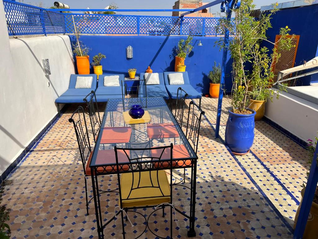 Riad Villa El Arsa في مراكش: طاولة وكراسي على شرفة بها نباتات