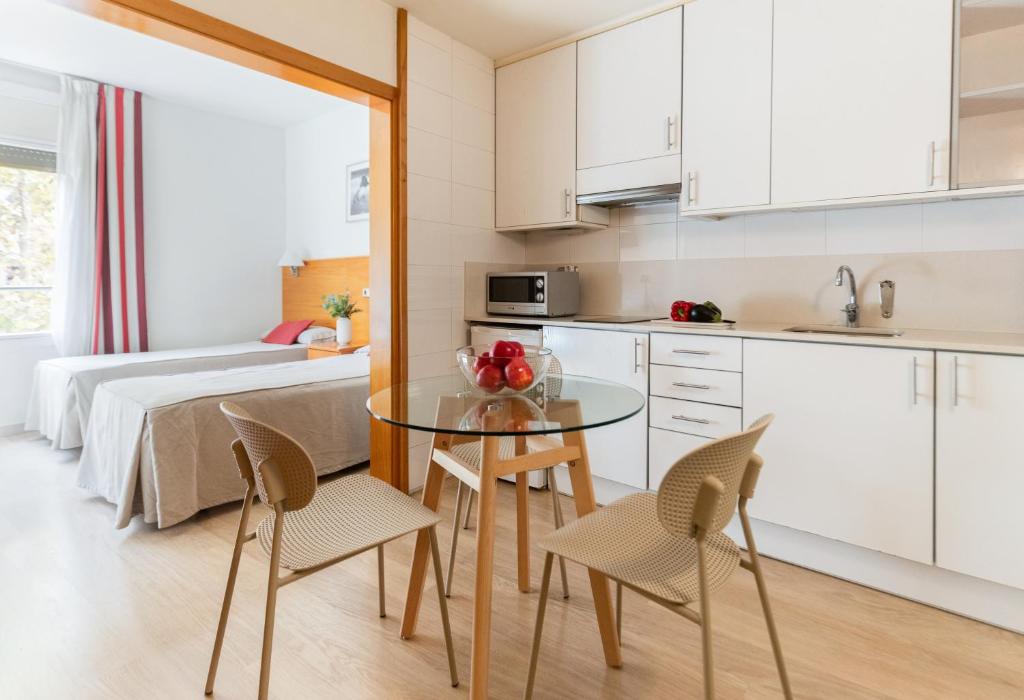 a kitchen and dining room with a glass table and chairs at Atica Apartments - by Weflating in Barcelona