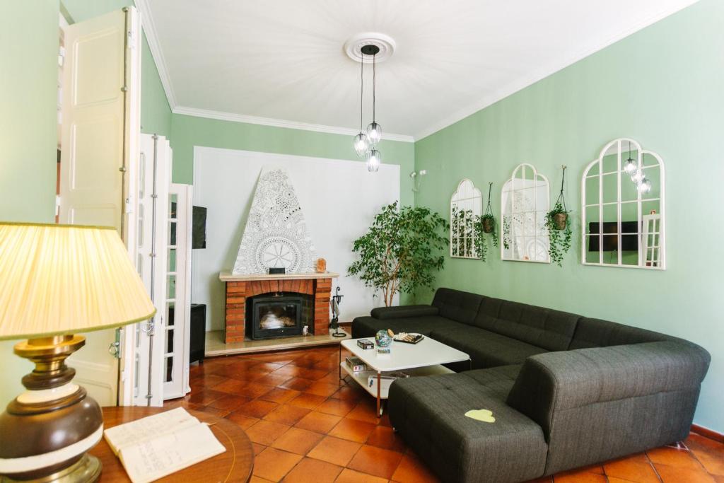 a living room with a couch and a fireplace at Eco Ljmonade Hostel in Cascais