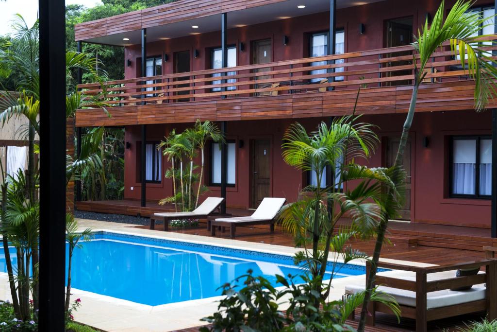 a hotel with a swimming pool in front of a building at Costa Iguazu in Puerto Iguazú