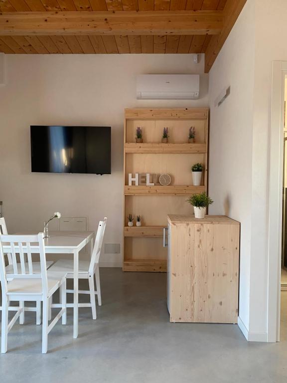 uma sala de jantar com mesa e cadeiras e uma televisão em Olea b&b em Montecosaro