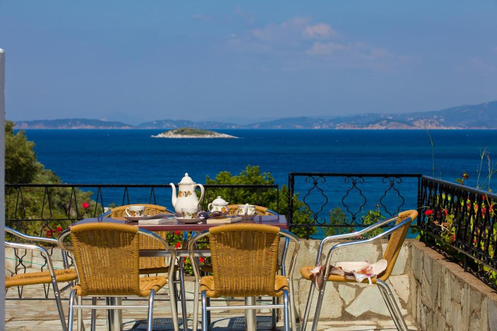 a table and chairs with a view of the ocean at Hovolo Hotel Apartments in Neo Klima